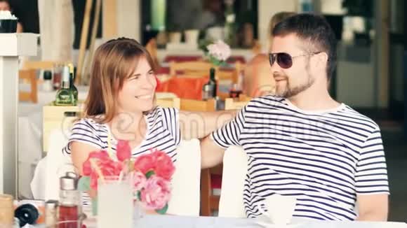 年轻幸福的一对夫妇度假时坐在街头咖啡馆里视频的预览图