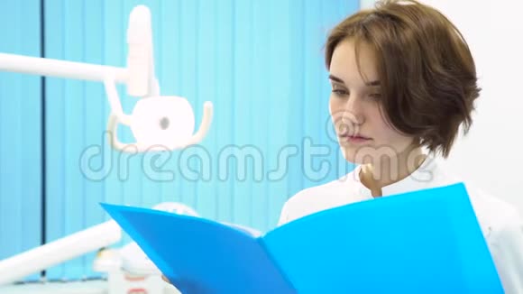 女医生在牙医柜前阅读病人笔记医疗设备保健理念女牙医视频的预览图