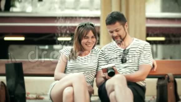 年轻快乐的一对夫妇在度假时用紧凑型相机看照片视频的预览图