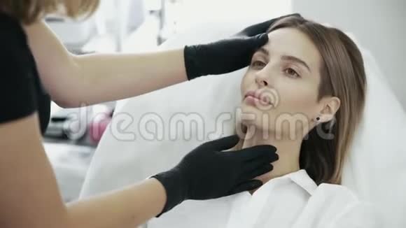 近距离的年轻女性在脸上显示美容师的区域以便注射和治疗视频的预览图