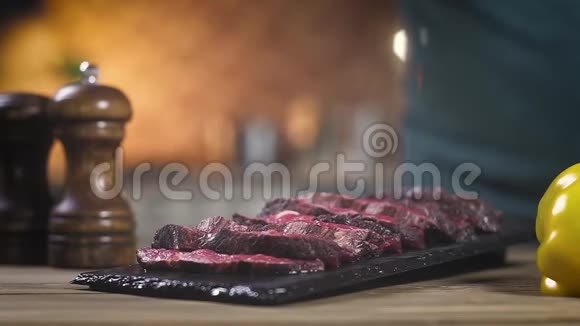 切片烤肉放在黑摊上厨师用手撒红胡椒和盐特写慢动作视频的预览图