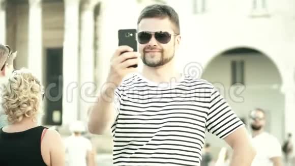 一个留胡子的年轻人在度假时用手机自拍视频的预览图