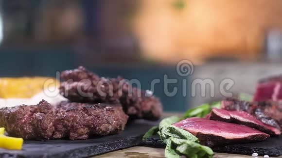 切片烤肉放在黑摊上为汉堡烤肉绿色薄荷叶调味品一切都在桌子上这就是视频的预览图