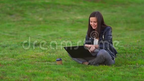 公园里的小女孩带着笔记本电脑在视频通话中交谈视频的预览图