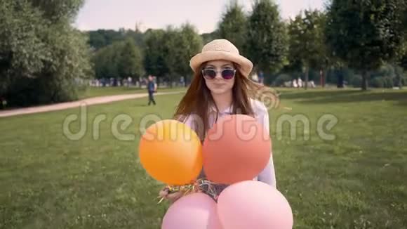 戴着帽子的姜黄色女人带着气球跑过去拍照视频的预览图
