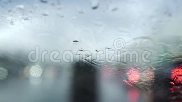 挡风玻璃雨刷在潮湿的天气工作道路景观通过车窗雨滴视频的预览图