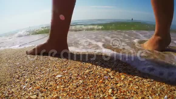 女性的腿沿着海岸行走留下痕迹视频的预览图