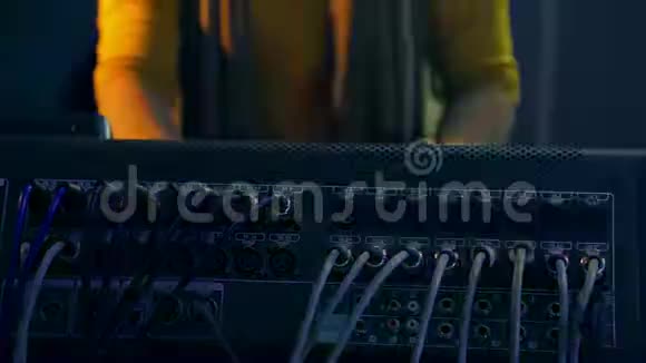 在迪斯科的灯光下在混合控制台后面的女性DJ的手视频的预览图
