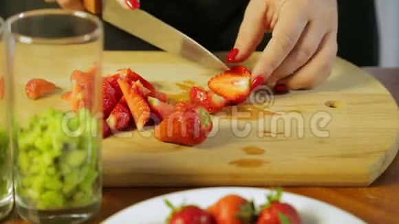 一个女人用一把大刀在木板上用一把大刀切熟草莓视频的预览图