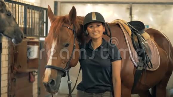 骑师女士站在一匹棕色的马旁边微笑着视频的预览图