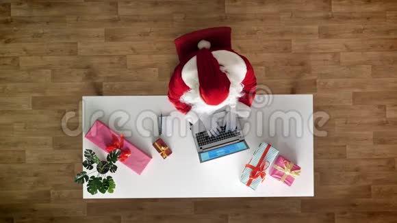 圣诞老人在办公室工作手提电脑打字鸟瞰上下拍摄给笔记本写文字视频的预览图