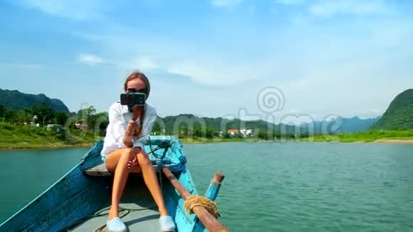 女孩坐在木船船头对着河自拍视频的预览图