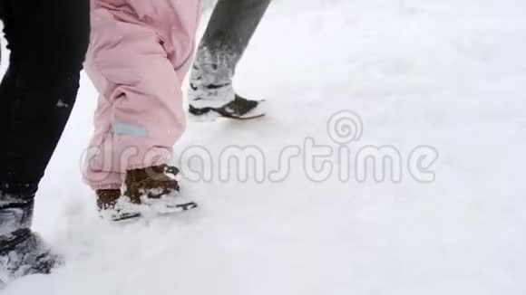 穿暖和连衣裙的婴儿脚做第一步孩子学会走路友好的全家人在冬季森林散步视频的预览图