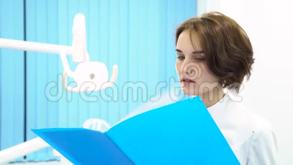 女医生在牙医柜前阅读病人笔记医疗设备保健理念女牙医视频的预览图