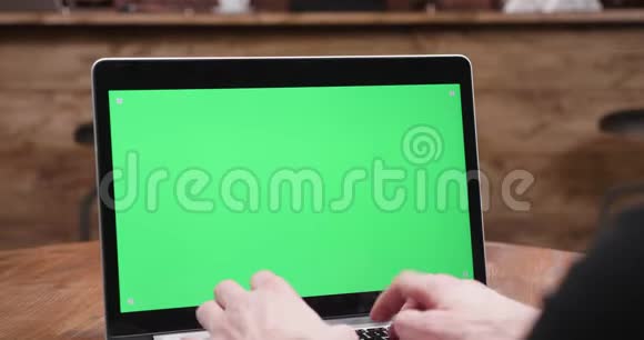 静态镜头男性手打字在现代笔记本电脑与绿色屏幕显示视频的预览图