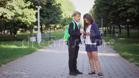 男孩和女孩在公园小巷里用一本数字书视频的预览图