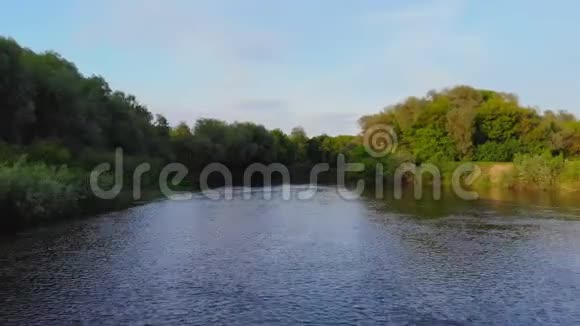 空中低飞在绿松石色的河流之上穿过春天的山谷视频的预览图