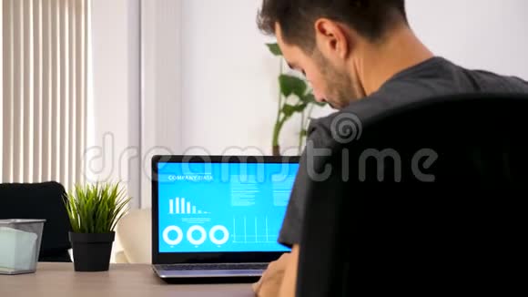 一个人在笔记本上写下笔记同时看电脑屏幕上有动画数据视频的预览图