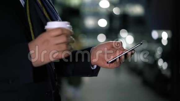 中弹的男性手拿着一杯咖啡在手机上视频的预览图