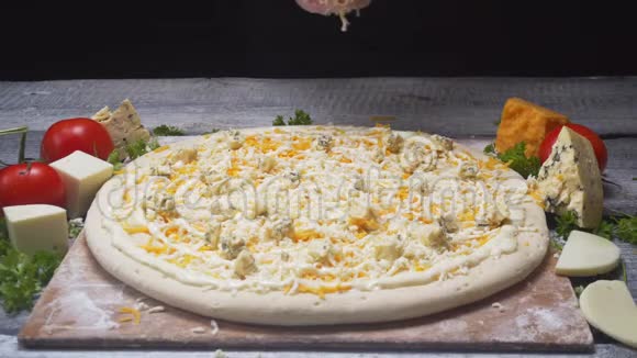 厨师的特写他的手在木板上加入四个奶酪比萨饼中的奶酪框架美味的披萨准备视频的预览图