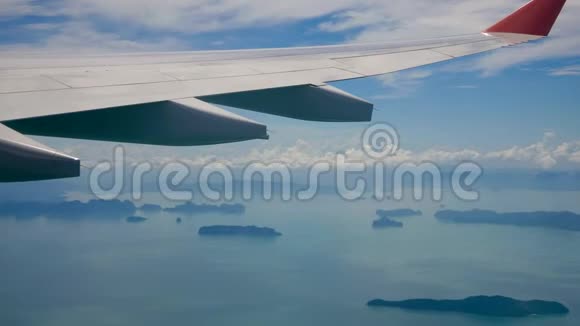 从窗外看到一架飞机飞过热带岛屿的海面视频的预览图