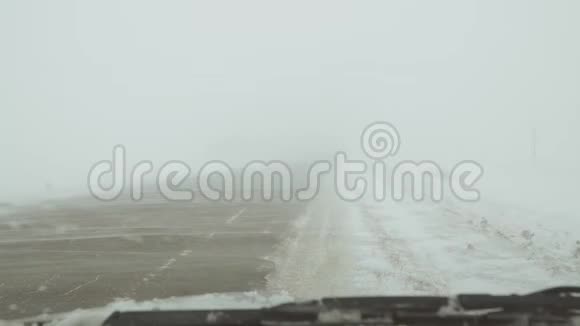 路上的暴风雪风覆盖着雪的道路视频的预览图