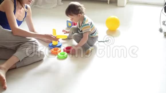 小宝宝和妈妈在白地板上玩耍视频的预览图