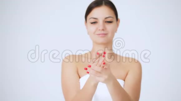 年轻女性涂抹手部保湿霜整洁的双手白色背景皮肤护理视频的预览图