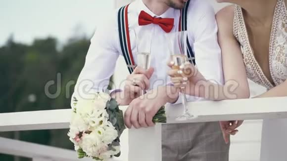 新婚夫妇举着香槟酒杯和结婚花束视频的预览图