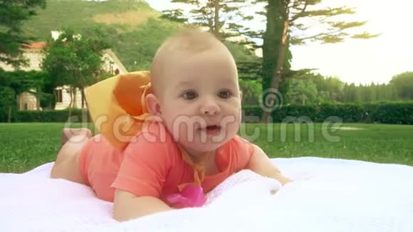 宝宝躺在草地上的毛巾上特写镜头视频的预览图
