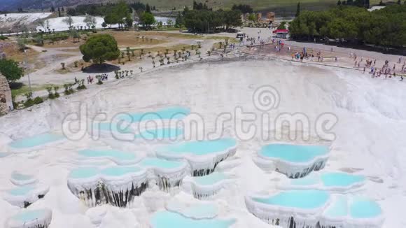 帕穆卡莱的天然石灰华白色石灰石矿层背景为游客空中镜头视频的预览图