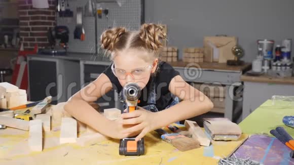 小10岁的女孩和一个手里的钻头慢动作年轻漂亮的女建筑工人手里拿着钻视频的预览图