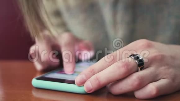 在一家咖啡馆里在连接到wifi网络的智能手机上特写女性手键入文本视频的预览图