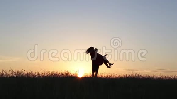 年轻的男人在河的边缘挥动着他爱的女人日落的光视频的预览图