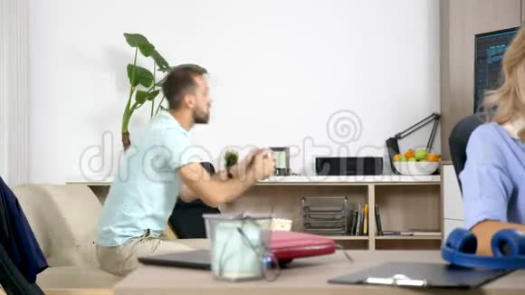 男人在控制台上玩电子游戏当她的伴侣试图在电脑上工作时发出噪音视频的预览图