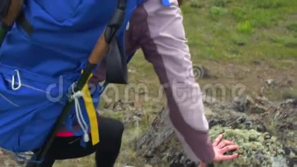 快乐的女人在户外跋涉时爬上岩石无忧无虑的背包客视频的预览图