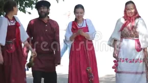 一群穿着俄罗斯民族服饰在大自然中行走的男女微笑庆祝活动视频的预览图