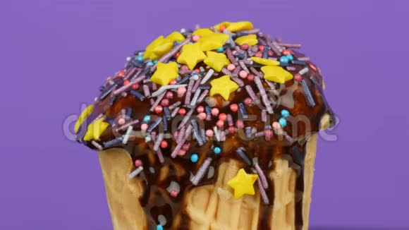 香草冰淇淋装饰在顶部与沉睡的蓝色彩色洒在浅紫色背景旋转视频的预览图