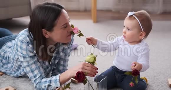 小女孩和妈妈把玫瑰花插在花瓶里视频的预览图