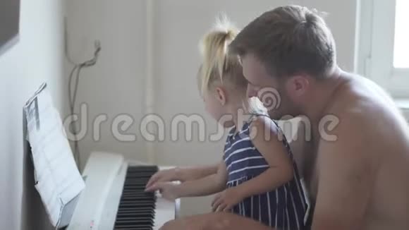 爸爸和他的小女儿弹钢琴视频的预览图