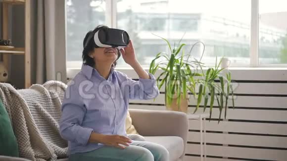 穿着蓝色衬衫戴着虚拟现实眼镜的女人视频的预览图