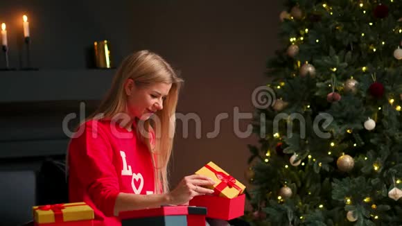 带着圣诞帽的女孩许愿并打开圣诞礼物包节日和新年的概念视频的预览图