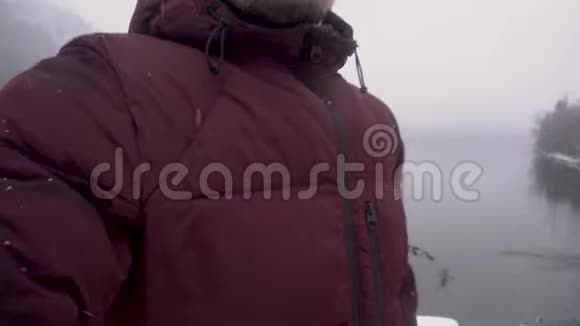 快乐旅行者男子自拍并显示里萨湖在阿布哈兹冬季视频的预览图