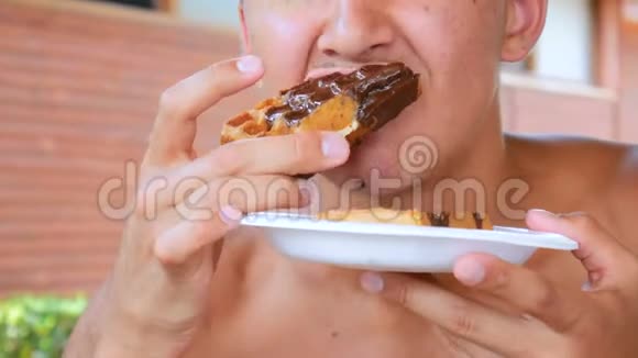 年轻人在海滩上的一家咖啡馆里吃着带有巧克力馅的华夫饼视频的预览图