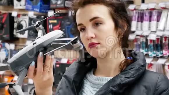 电子商店的女孩选择灰色无人机视频的预览图