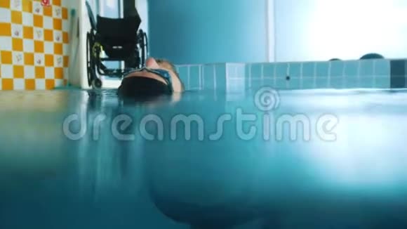 残疾人躺在游泳池里的水上水下射击视频的预览图