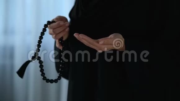 戴头巾的阿拉伯女性手里拿着念珠祈祷宗教宽恕视频的预览图