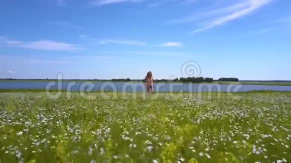 快乐的微笑女孩奔跑在盛开的荞麦田上视频的预览图