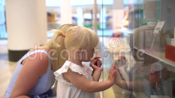 现代家庭的购物日小女孩在她想要礼物的玩具上表演这个小白毛孩长得真漂亮视频的预览图