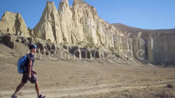 一个年轻的旅行者沿着山区的小路走视频的预览图